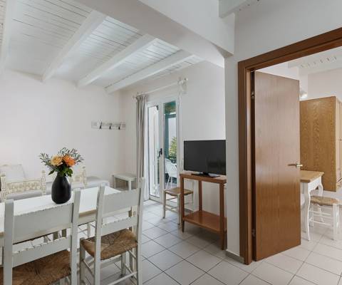 Marni Hotel Two Bedroom Apartment living area with dining table, TV and access to private balcony