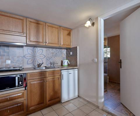 Marni Hotel Junior Apartment kitchenette with wooden cabinets and patterned backsplash tiles