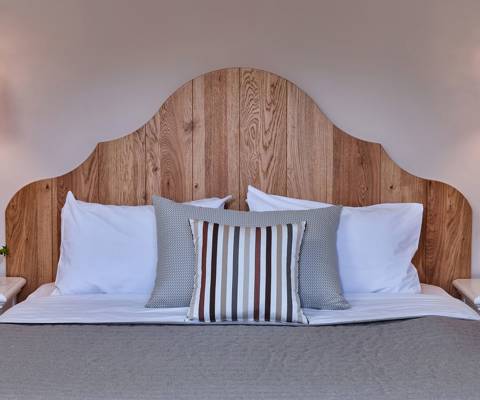 Marni Hotel Junior Apartment bed with striped pillows, wooden headboard and ceramic lamps