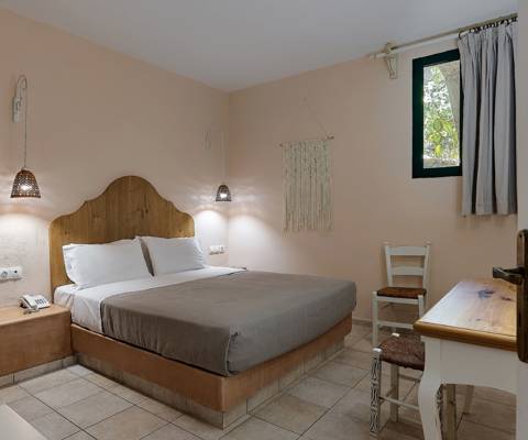 Marni Hotel Junior Apartment bedroom with double bed and rustic decor