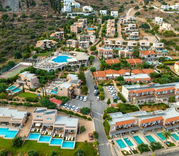 Marni Village aerial view of Hersonissos coastline and hillside suites with private and shared pools