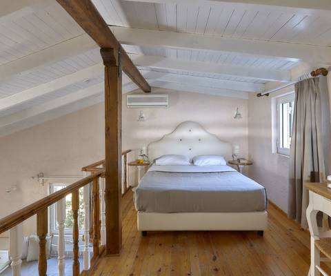 Marni Hotel Maisonette loft bedroom with pitched wooden ceiling, double bed and natural light