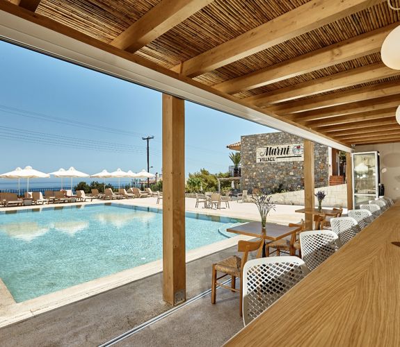 Marni village bar under wooden pergola near the pool with umbrellas and sunbeds